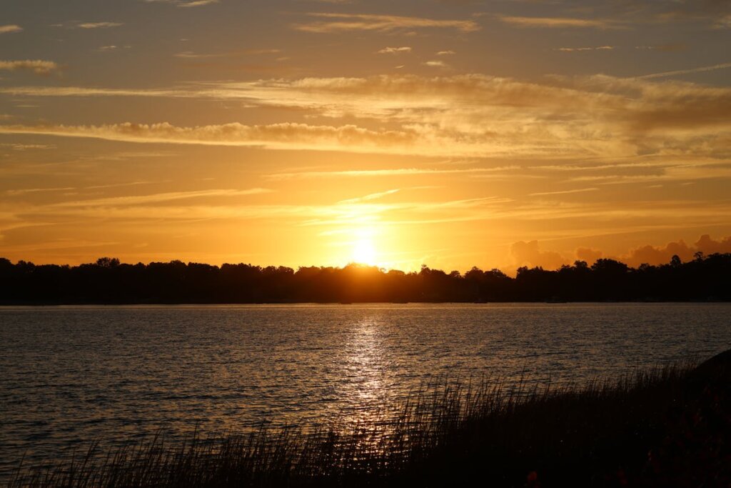 A view of a body of water with a sunset in the backround