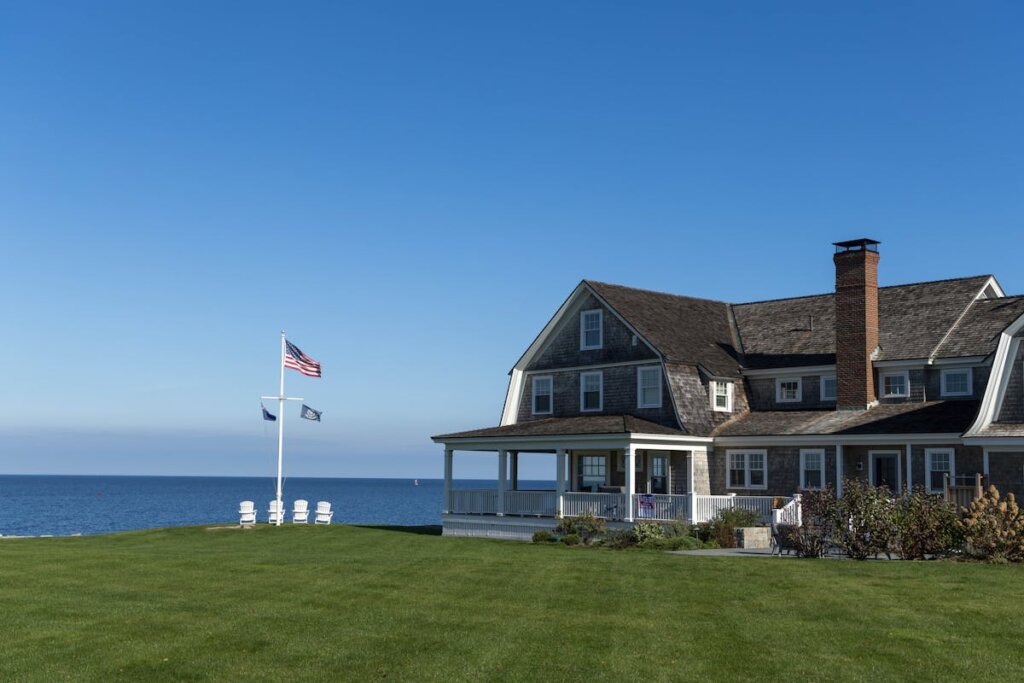 A house with a flag pole in the front yard by the ocean