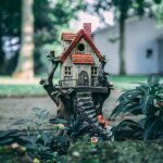 A small house sitting on a fake stump