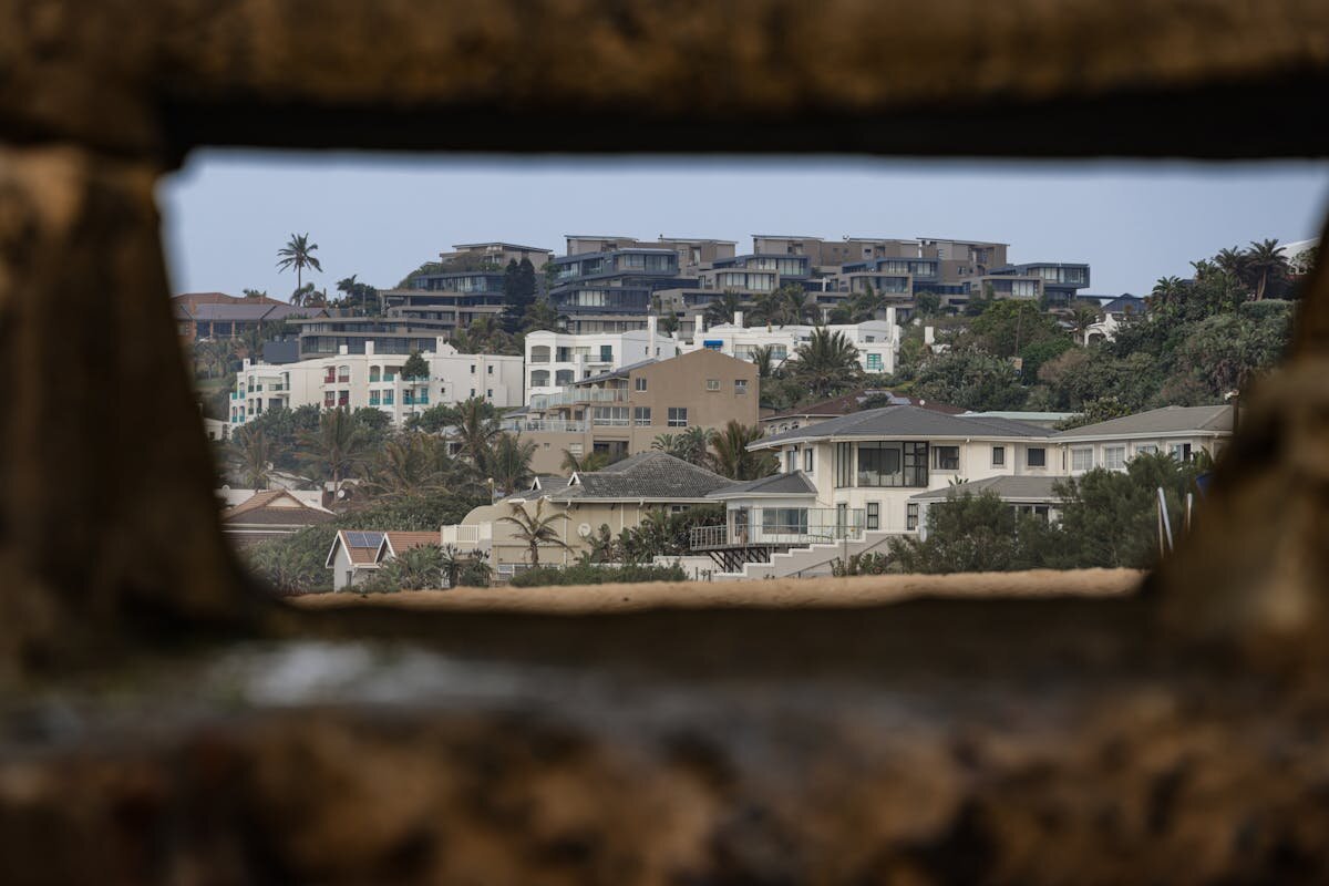 A person looking at a bunch of homes through a metal hole