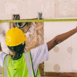 An electrician measuring a wall for wiring