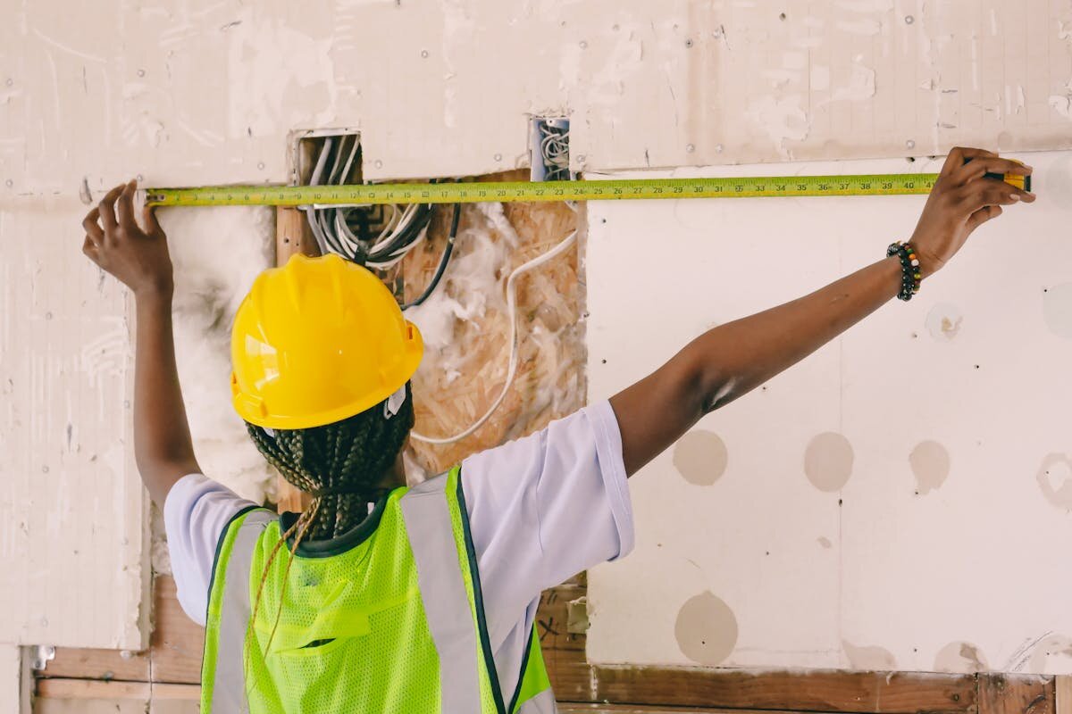 An electrician measuring a wall for wiring