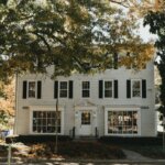 A colonial house in front of a street corner