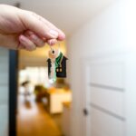 A person holding a key in front of an open door