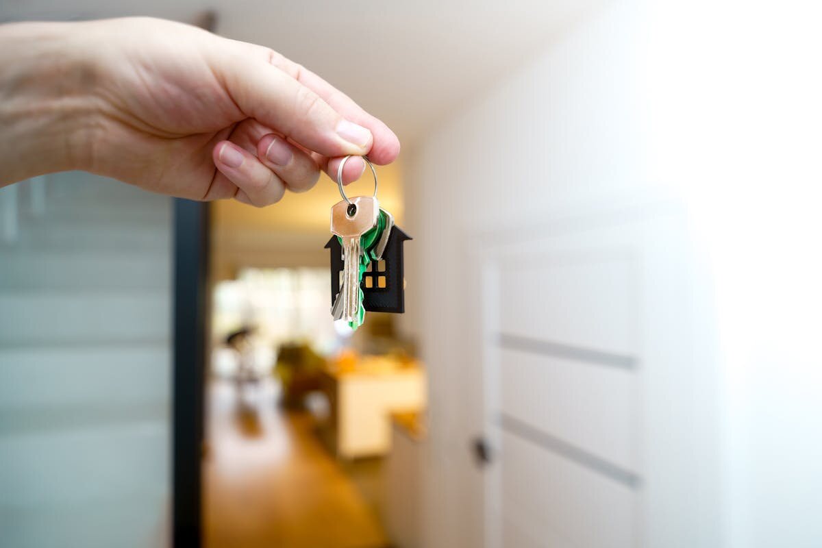 A person holding a key in front of an open door