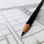 A blueprint of a house with a pencil on top of it