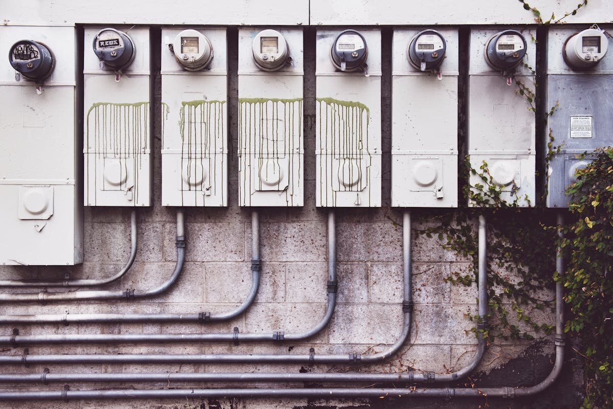 A bunch of electrical units on the outside of a building