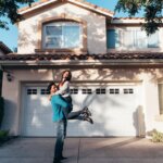 A couple in front of a house after purchasing it