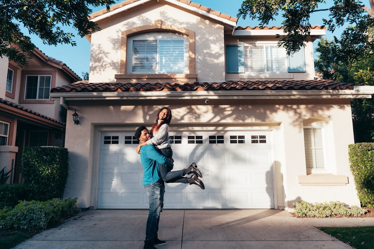 A couple in front of a house after purchasing it