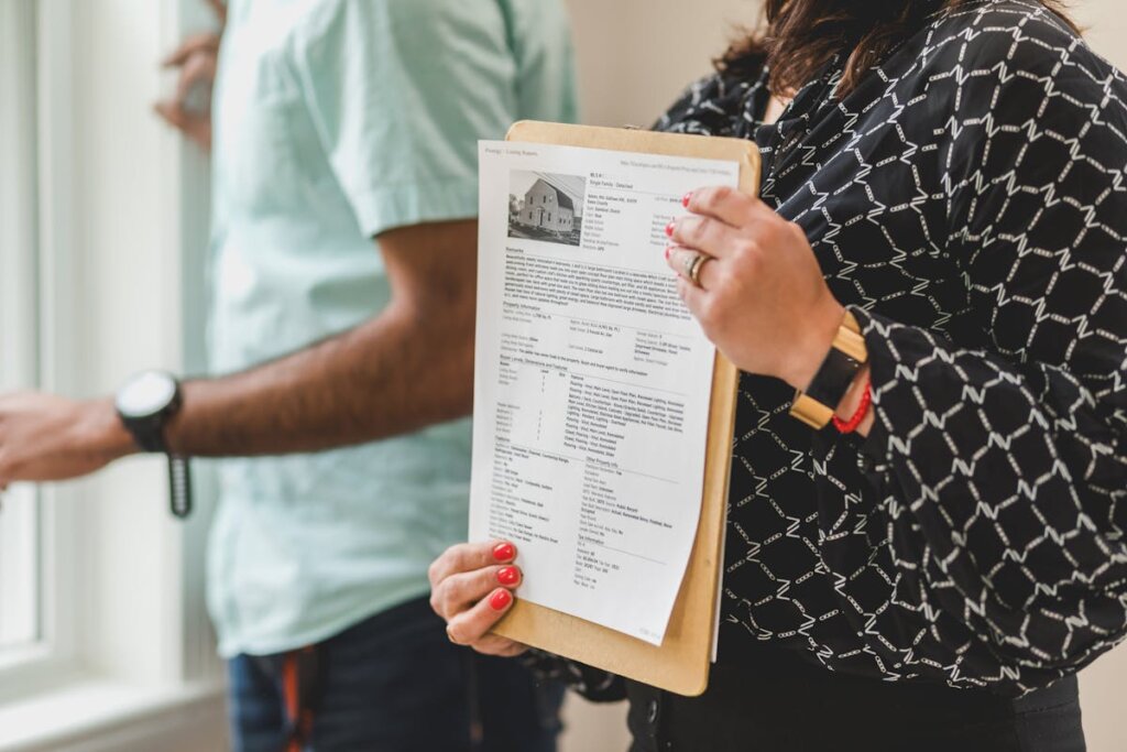 A person holding a house listing on a clipboard in front of them