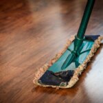 A swiffer broom cleaning a hardwood floor