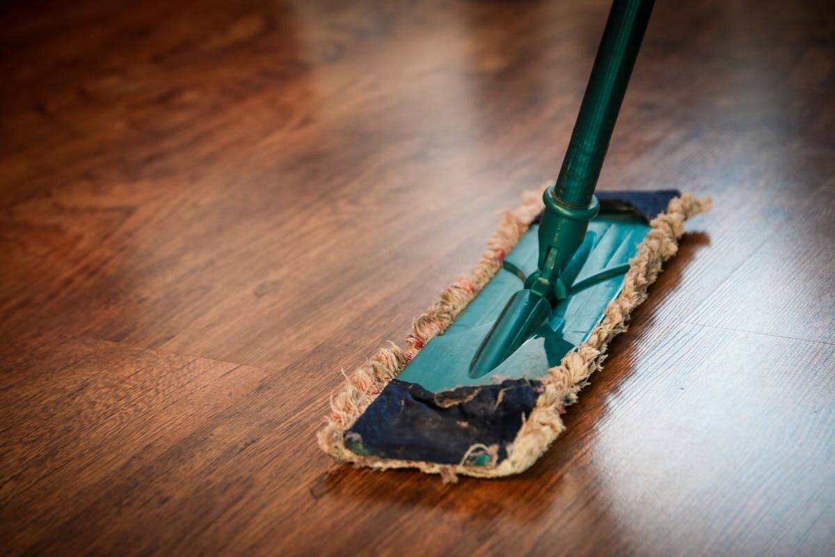 A swiffer broom cleaning a hardwood floor