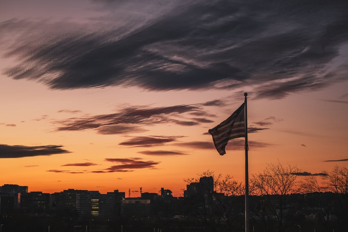 A flag with a city and a sunset in the distance