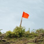 A red flag sitting on a hill