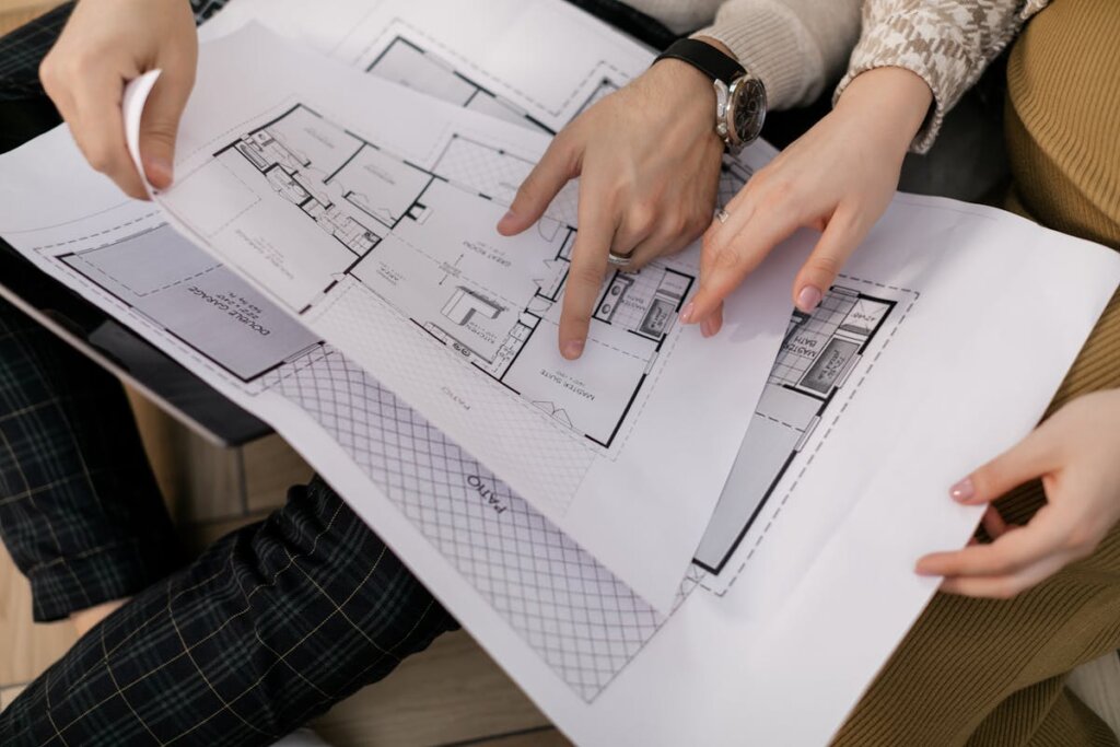 A couple people looking at blueprints for a house