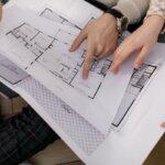A couple people looking at blueprints for a house
