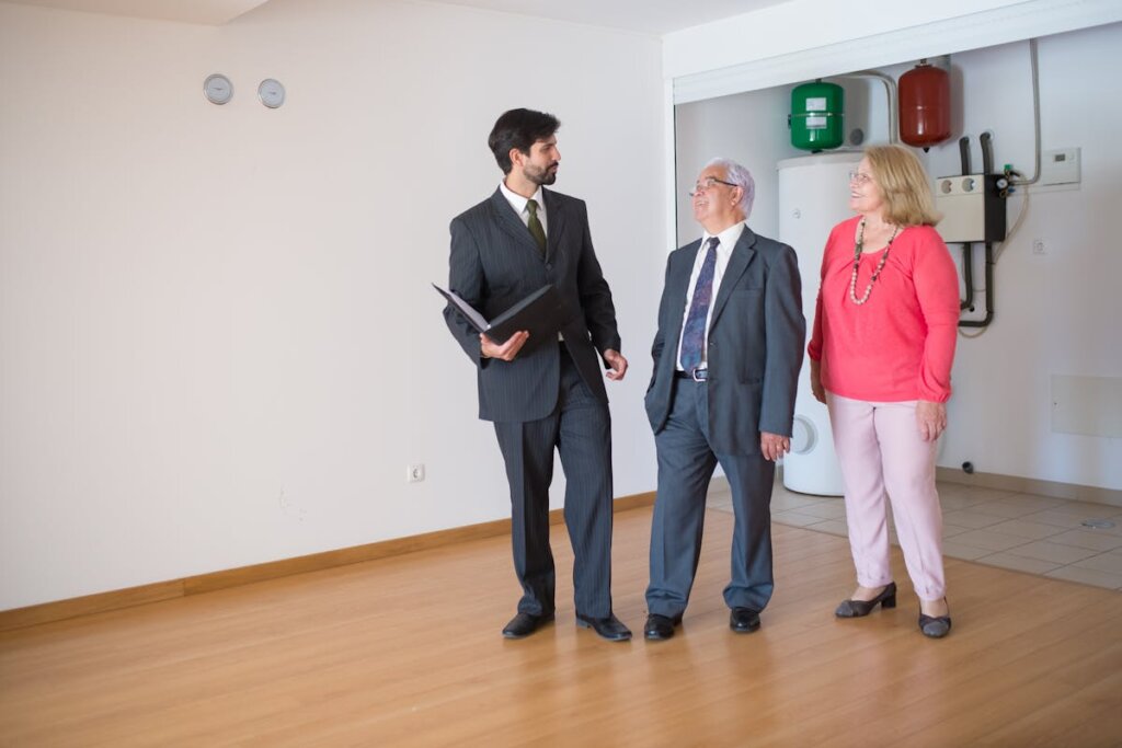 A person showing a house to an older couple