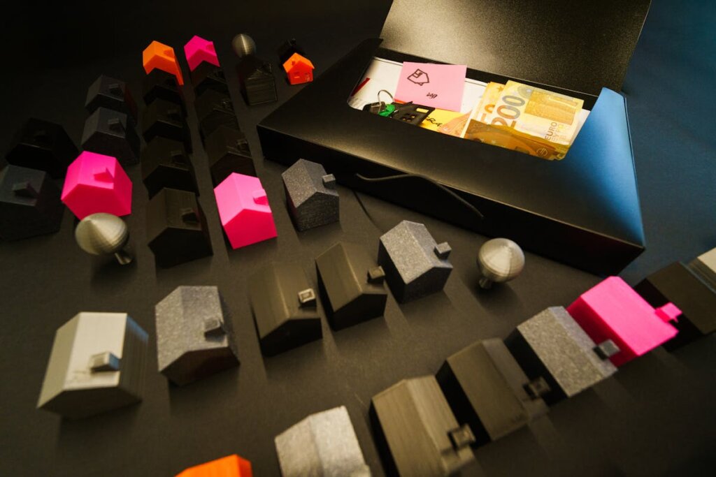 A bunch of little plastic houses with some money around it