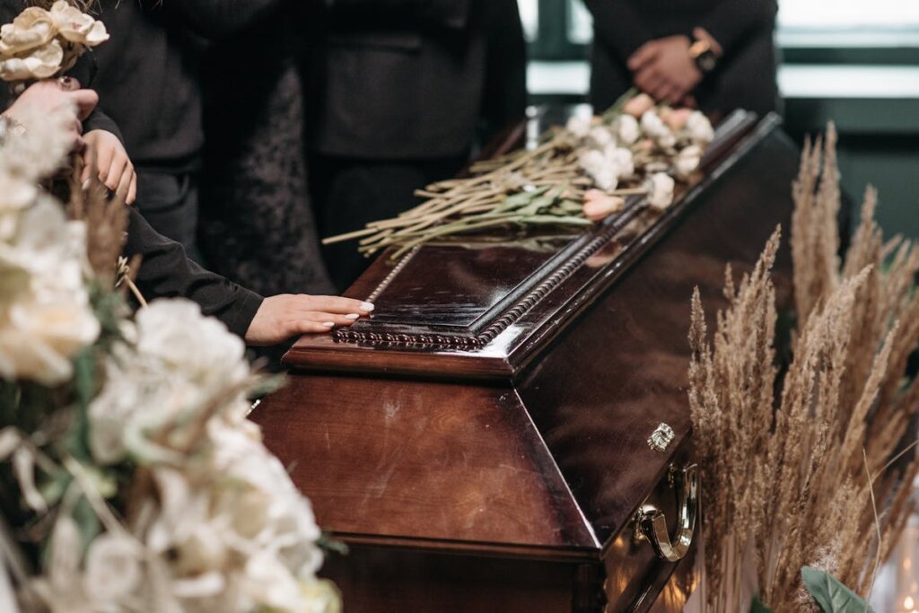 A family at a funeral looking at a coffin