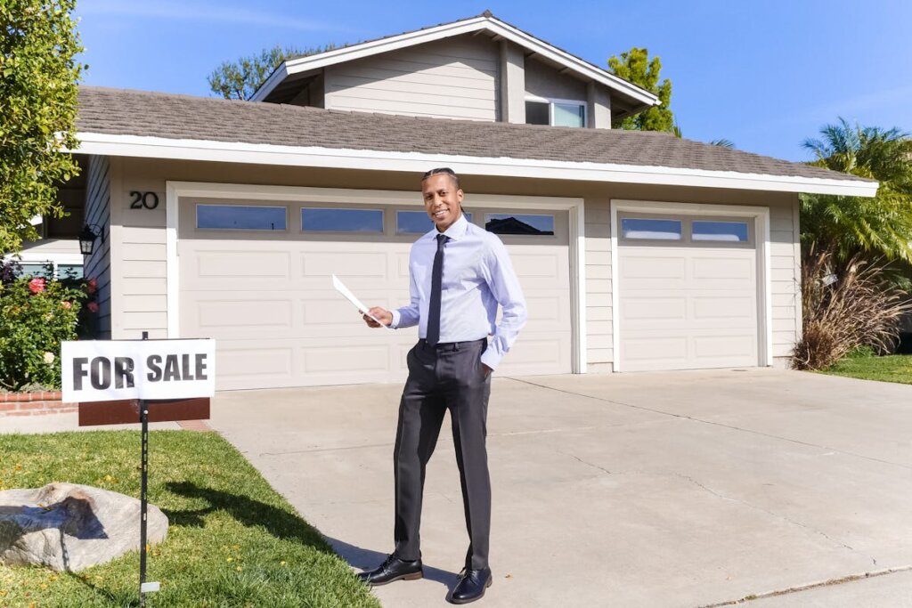 A real estate agent standing outside of a house being sold