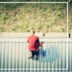 A man is sitting on top of a metal roof.