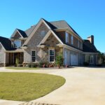 A driveway leading to a house with a roofing material pathway.