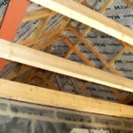 The roof of a house is being built with wooden beams.