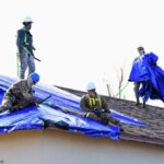 A professional roofing inspection of a blue tarp on a roof.