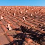 A commercial roof with red tiles and a blue sky.