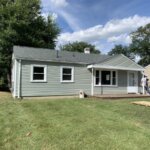 A house is being remodeled with new roof and siding, addressing wind damage.