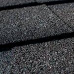 A close up of a black shingled roof with shingle roofing.