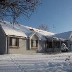 A house covered in snow after winterizing your roof.