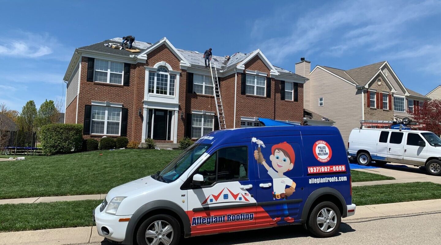 A van is parked in front of a house. The homeowners are considering hiring a roofing contractor to inspect and repair the roof.