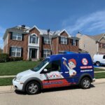 A van is parked in front of a house. The homeowners are considering hiring a roofing contractor to inspect and repair the roof.