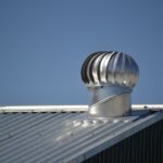 A metal chimney on top of a metal roof with metal roofing.