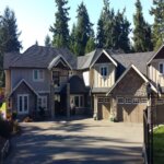 A leaky roof house with two garages and a driveway.