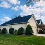 A house with a garage in front of it, perfect for DIY roofing.