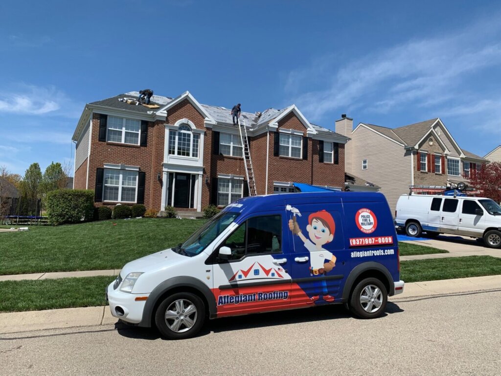 A van advertising roof replacement services is parked in front of a house.