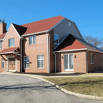 A brick home with a summer-ready red roof.