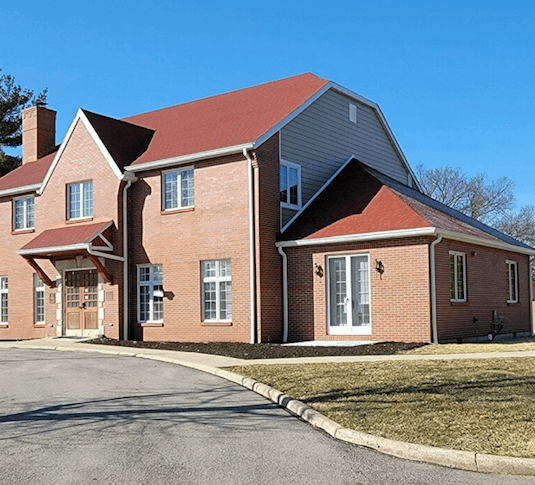 A brick home with a summer-ready red roof.