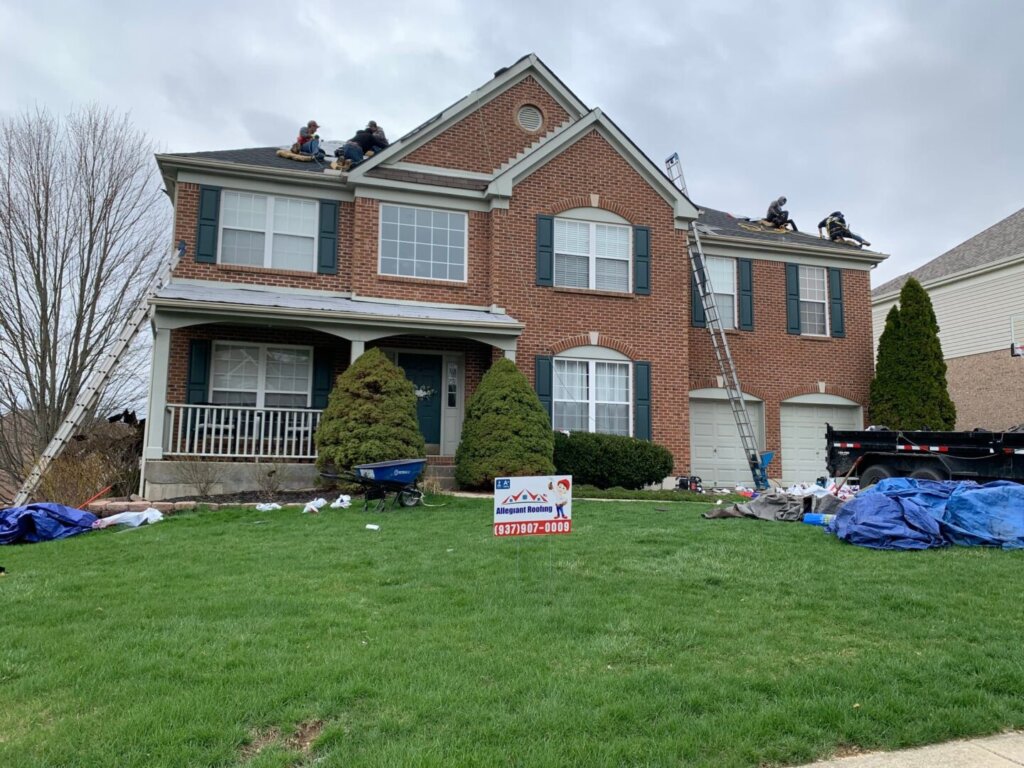 A group of men are working on a roof replacement job.
