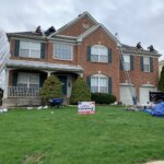 A group of men are working on a roof replacement job.