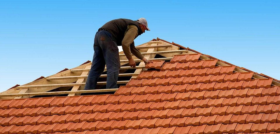 A man is working on a *commercial* roof.