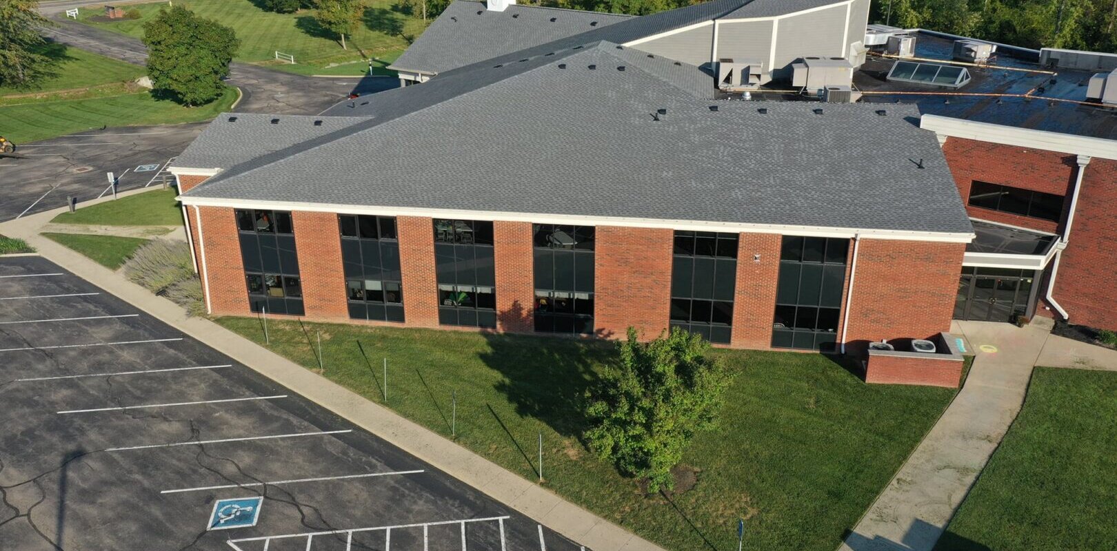 An aerial view of a church building with a commercial roofing.