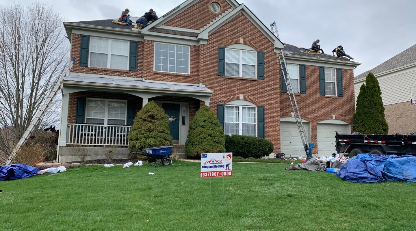 A group of men are conducting a roof inspection on a house.