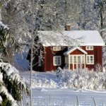 A red house with snow on the roof.