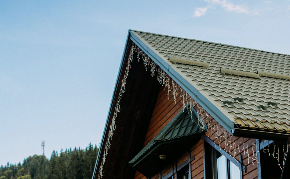 green metal roof with red house and bright blue sky