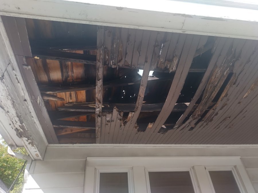 Rotted porch deck boards and framing on older Buffalo NY home — untreated dimensional lumber failure common in pre-1970 WNY housing stock