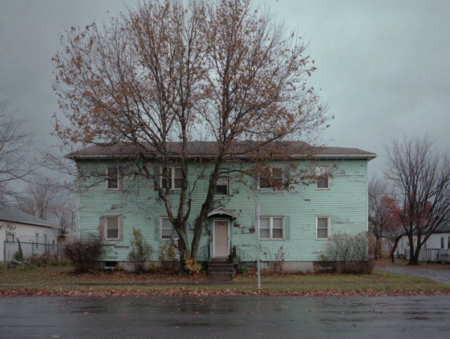 Worn multi-unit rental building in South Buffalo NY in late autumn — deferred maintenance typical of Erie County rental stock that drives landlord burnout