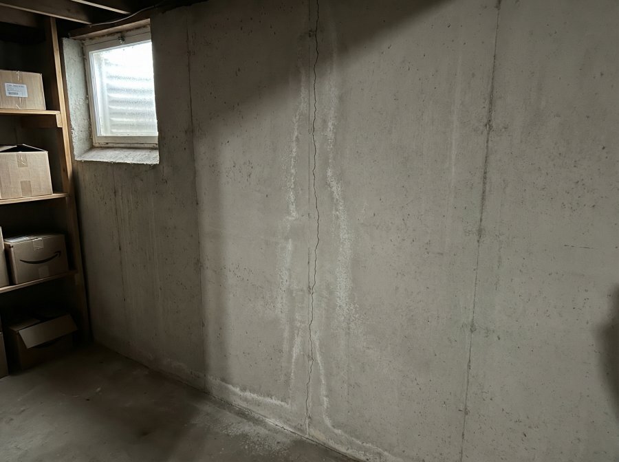 Vertical hairline crack in poured concrete foundation typical of Buffalo New York residential homes